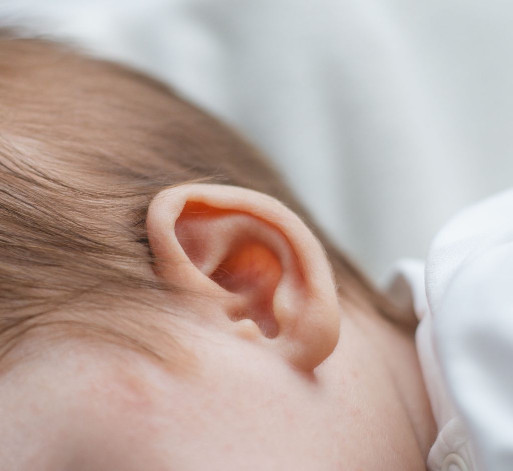 Detailed close-up of a newborn baby's ear, capturing softness and innocence.